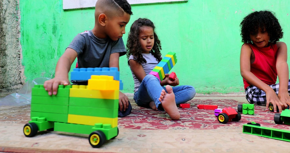 2 children being flexible by playing together in different ways with connectig blocks