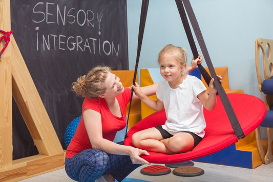 sensory integration therapy showing OT with child on a swing