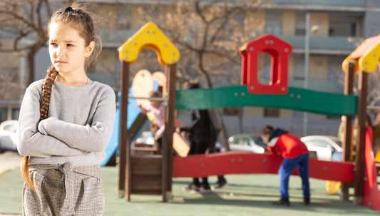 child with social anxiety standing alone on a playground