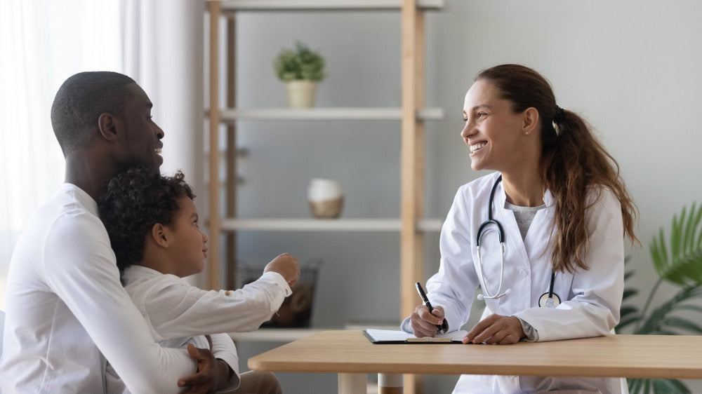 healthcare provider listening to child and parent and addressing child's behavior