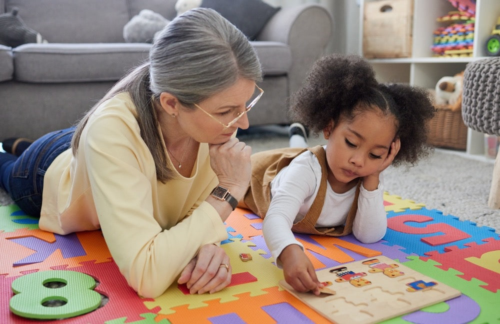 white woman with marginalized child doing a puzzle