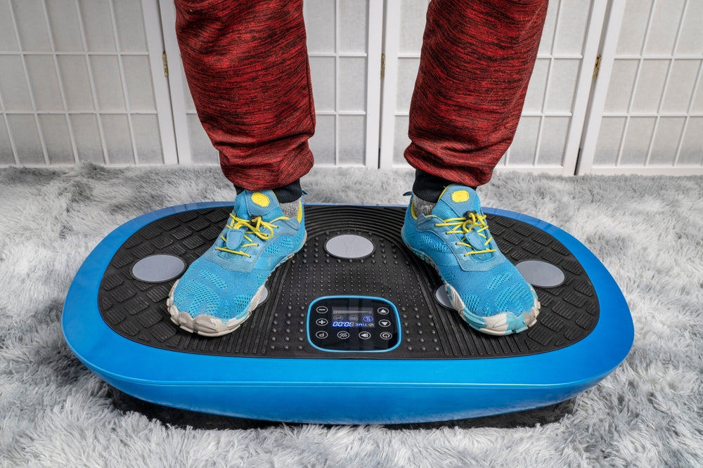view of man's feet standing on vibration board